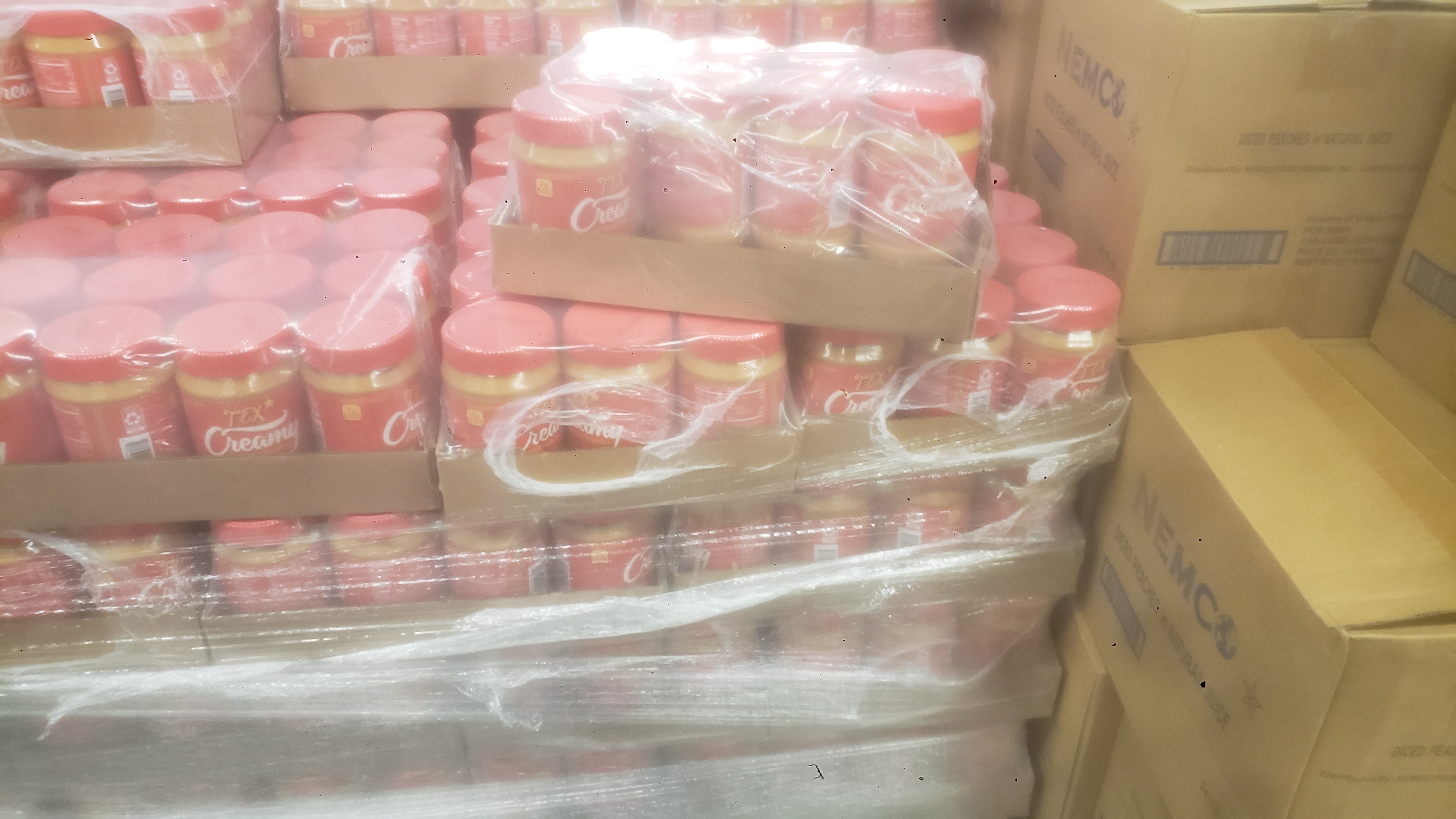 Trays of peanut butter jars on a pallet.